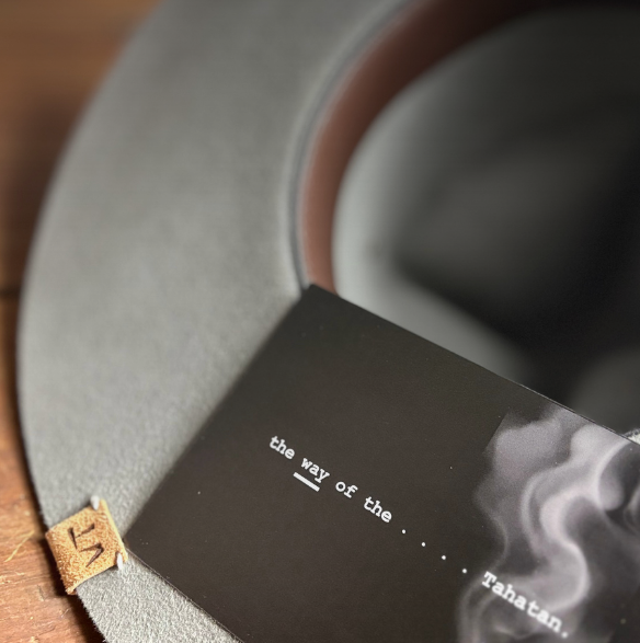 inside tahatan felt hat with a promo card in black and smoke reading the way of tahatan. vtc tab design in reclaimed leather