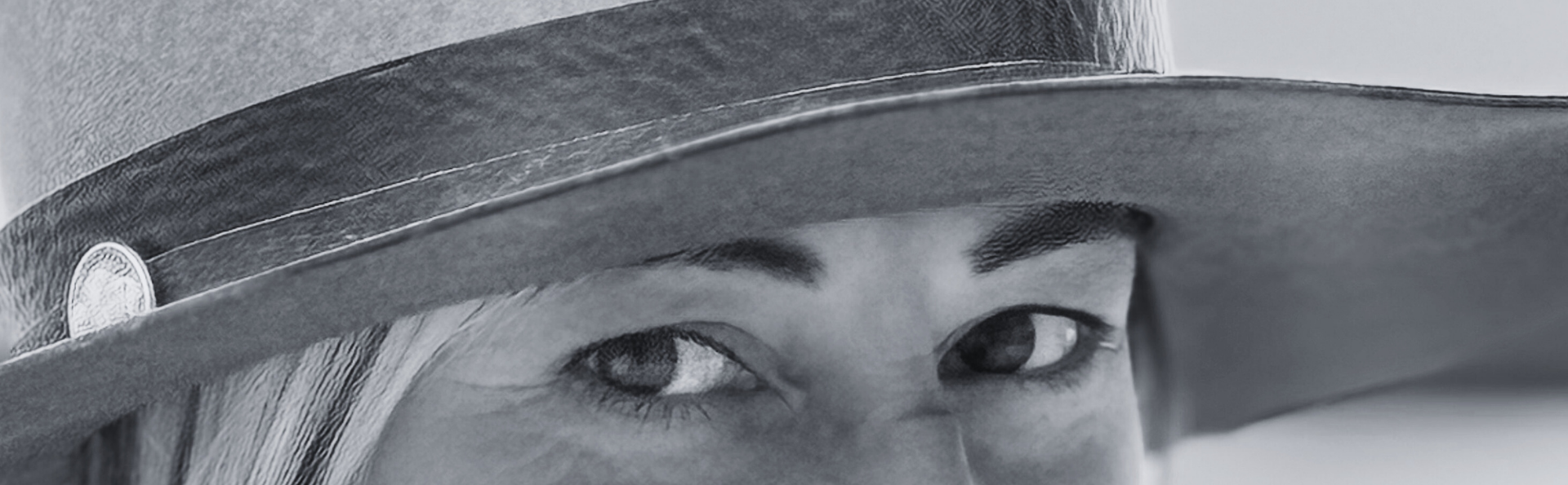 Black and white portrait of a person wearing a wide-brimmed hat.