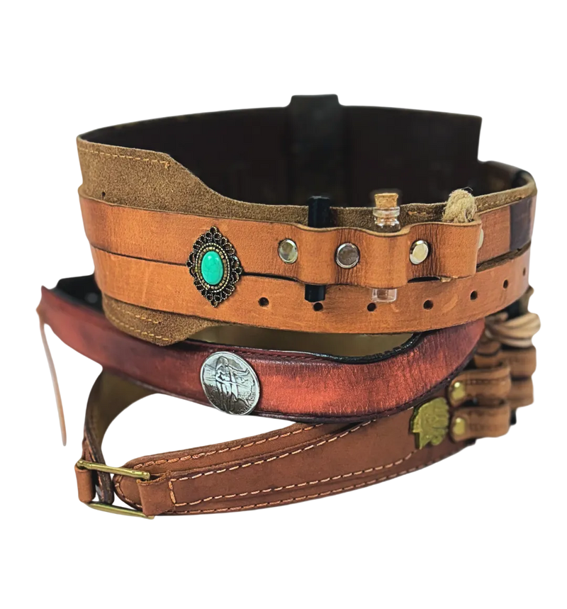 Stack of leather belts with decorative elements on a light gray background